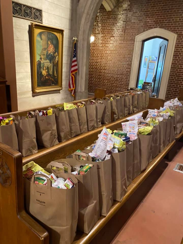 Brown bags full of food are lined up on pews, ready for distribution to our neighbors.