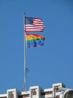 American flag and rainbow pride flag flying above the church